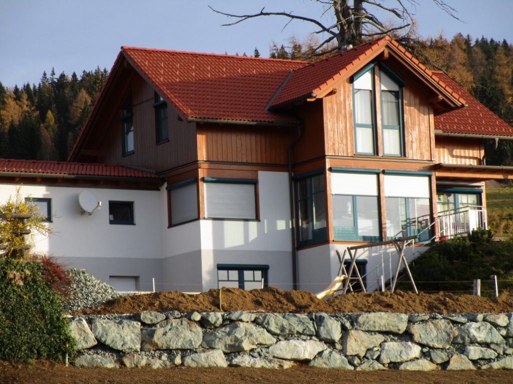Einfamilienhaus mit Natursteinmauer im Gartenbereich