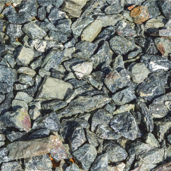 Kompakter, grobkörniger dunkler Schotter mit mineralischen Glanzpunkten