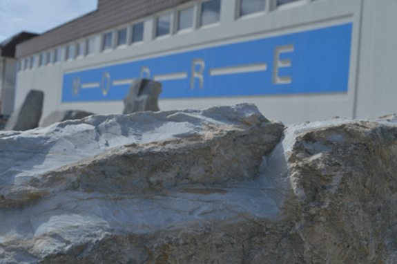 Firmengebäude mit MODRE-Schriftzug und Felsen im Vordergrund